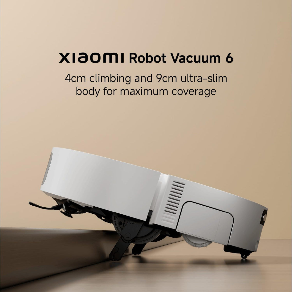 Xiaomi Robot Vacuum 6 shown on a wooden floor against a beige wall, with text above reading 'Xiaomi Robot Vacuum 6' and '4cm climbing and 9cm ultra-slim body for maximum coverage.'.