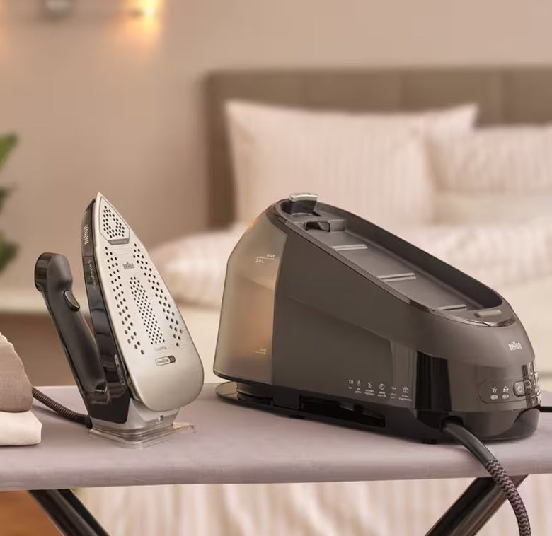 Taghareed Braun CareStyle 5 IS5249BK steam generator iron with 2L water tank and ergonomic handle, on ironing board.