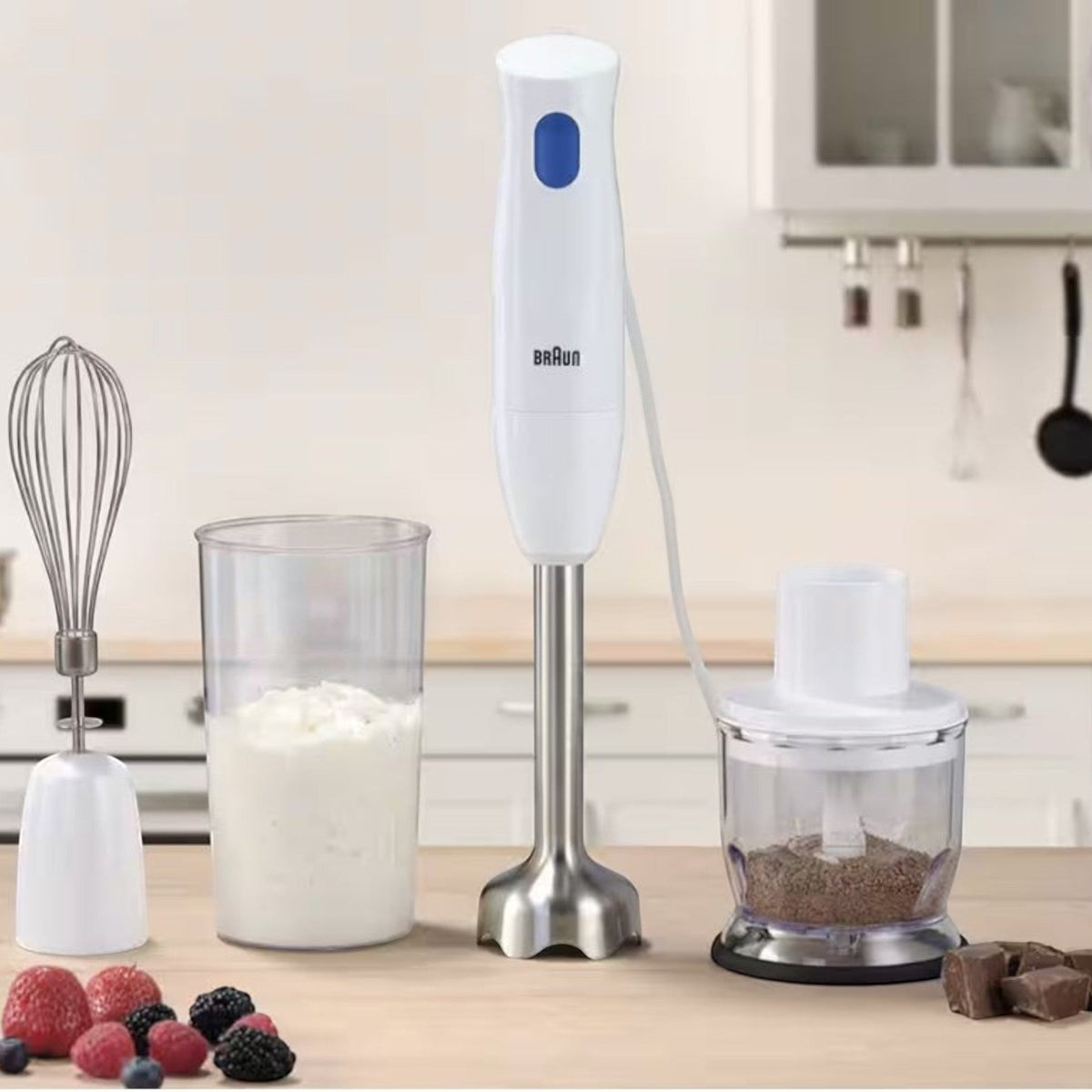 Taghareed Braun MultiQuick 1 hand blender in white with stainless steel shaft, whisk attachment, beaker, and chopper accessory.