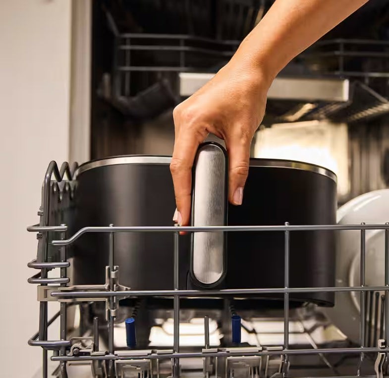 Taghareed Braun MultiFry 5 Air Fryer HF5030IBK, black, 6L capacity, dishwasher safe basket being placed in dishwasher.