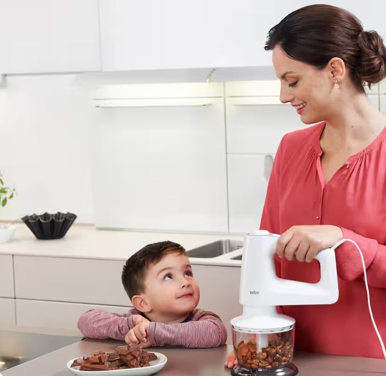 Taghareed Braun MultiMix 3 hand mixer in white with 5 speeds and SmartMix design, shown with a child and chocolate.