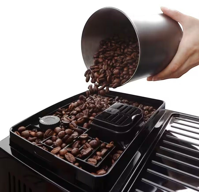 Taghareed De’Longhi Magnifica Start coffee machine bean hopper being filled with fresh coffee beans.