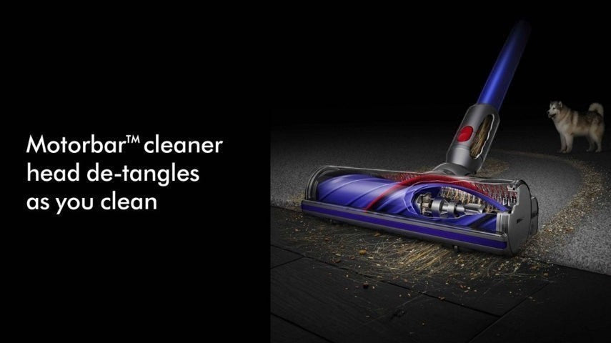 Taghareed Dyson cordless vacuum cleaner with Motorbar cleaner head de-tangling hair on dark wood floor.
