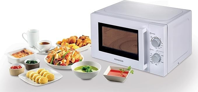 Taghareed Kenwood 20L white microwave oven with mechanical controls and defrost function, shown with various dishes of food.