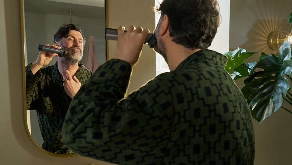Taghareed man with beard using Philips All-in-One Trimmer 7000 Series MG7922/15 for grooming in a bathroom.