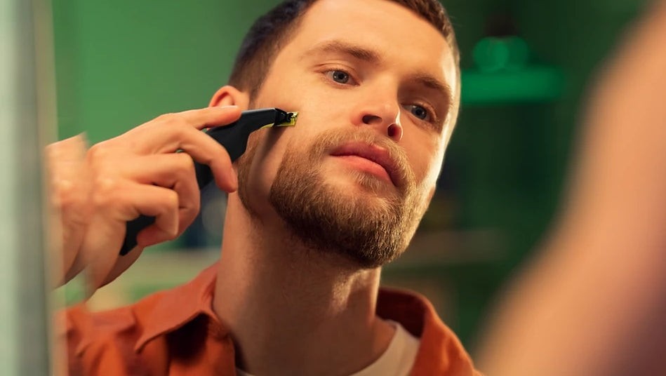 Taghareed Philips OneBlade Pro QP6542/10 electric trimmer for face and body grooming, black with yellow accents.