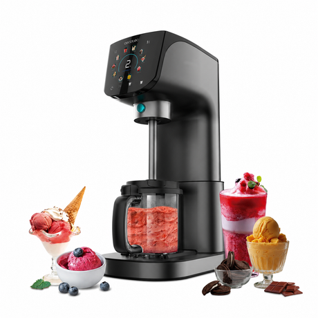 A sleek black countertop ice cream maker machine with a digital control panel and a clear pitcher filled with pink frozen dessert, shown on a white background with scoops of ice cream, berries, chocolate, and a sorbet styled around it.