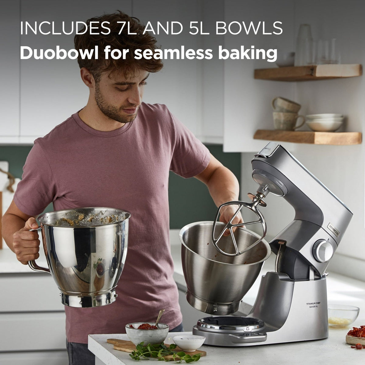 Person using a stand mixer with large bowls in a kitchen setting