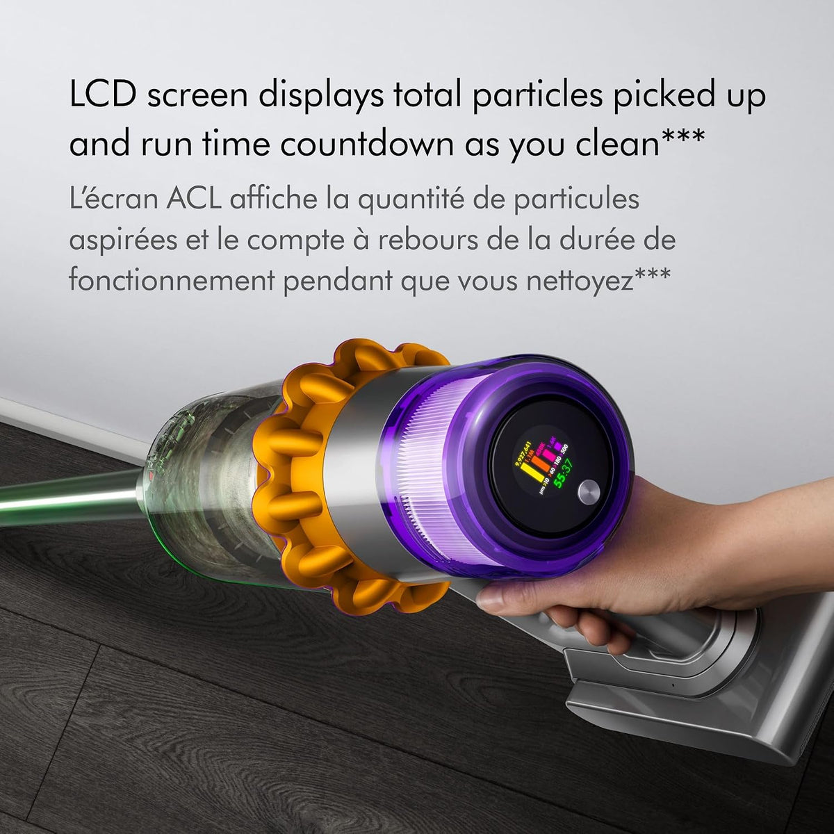 Hand holding a cordless vacuum cleaner with an LCD screen displaying cleaning information.