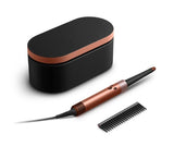 A hair styling tool set on a white background, featuring a black oval charging case with a metallic copper band, a matching copper and black styling wand, and a black comb.