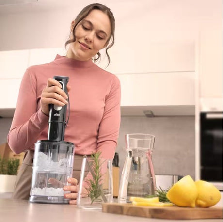 Braun MultiQuick 5 Pro hand blender with 1000W motor, 25 speed settings, and SplashControl technology, shown in use crushing ice.