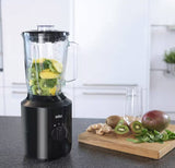 Braun PowerBlend 3 jug blender in black with a glass pitcher filled with kiwi and mango, ready to make a smoothie.
