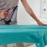 Braun TexStyle 1 steam iron in pink and black with a SuperCeramic soleplate, used on a teal shirt.