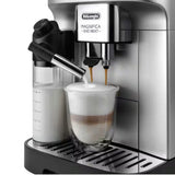 De'Longhi Magnifica Evo coffee machine making a latte with frothed milk and espresso in a glass cup.