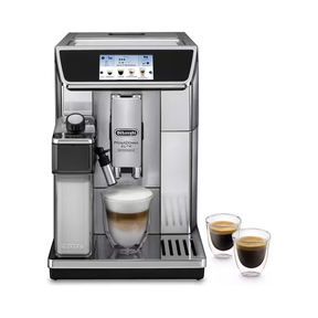 A De'Longhi Eletta Automatic Espresso Machine in stainless steel and black, shown with a glass of layered latte macchiato and two double-walled espresso cups on a white background.
