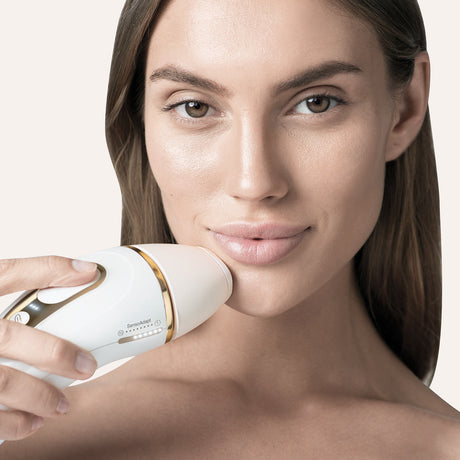 Braun Silk-expert Pro 5 IPL hair removal device with gold accents, showcasing its sleek design and treatment window.