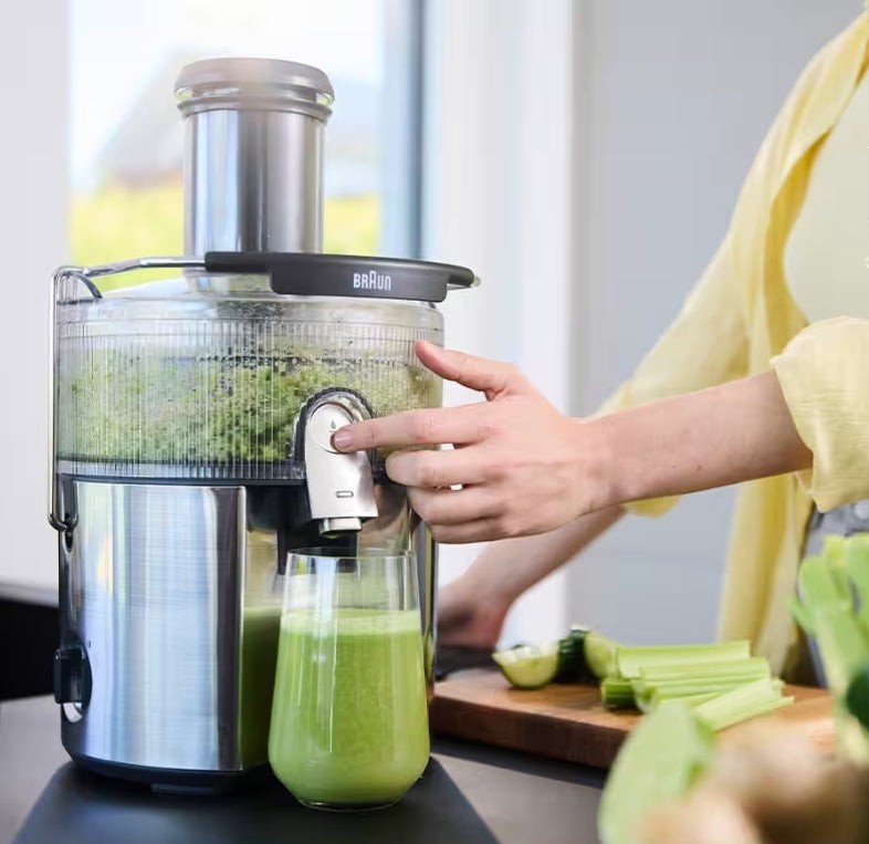 Taghareed Braun MultiJuice 7 Spin Juicer SJ7000 with 1000W motor, 75mm chute, and 2L pulp bin, making fresh green juice.