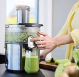 Taghareed Braun MultiJuice 7 Spin Juicer SJ7000 with 1000W motor, 75mm chute, and 2L pulp bin, making fresh green juice.