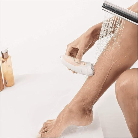 Taghareed Braun Silk-épil 5 epilator with MicroGrip technology being used on a wet leg under a shower.