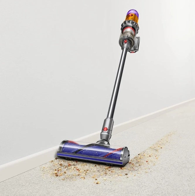 Taghareed cordless stick vacuum cleaner with purple top, cleaning debris from carpet. Powerful suction, lightweight design.