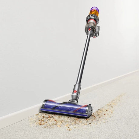 Taghareed cordless stick vacuum cleaner with purple top, cleaning debris from carpet. Powerful suction, lightweight design.