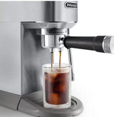 Taghareed De'Longhi Dedica Duo stainless steel espresso machine brewing cold brew coffee into a glass with ice.