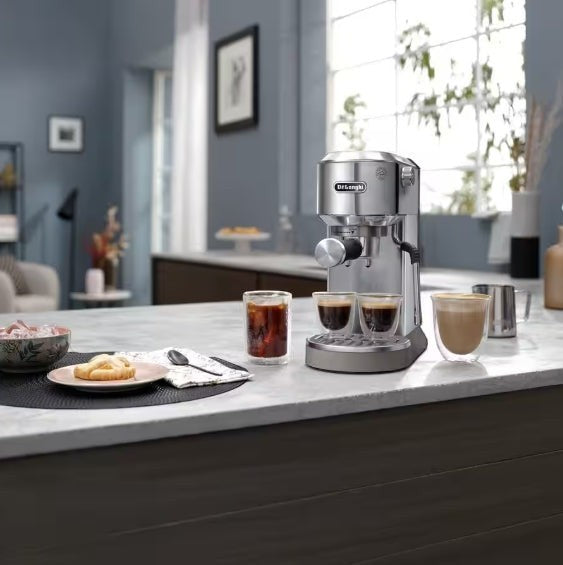 Taghareed De'Longhi Dedica Duo stainless steel espresso machine with cold brew option and steam wand, making coffee.