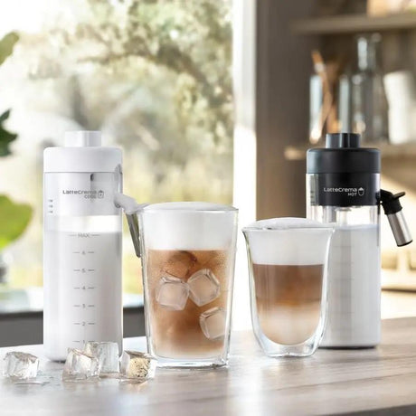 Taghareed De'Longhi Eletta Explore coffee machine with hot and cold milk carafes and two coffee drinks.