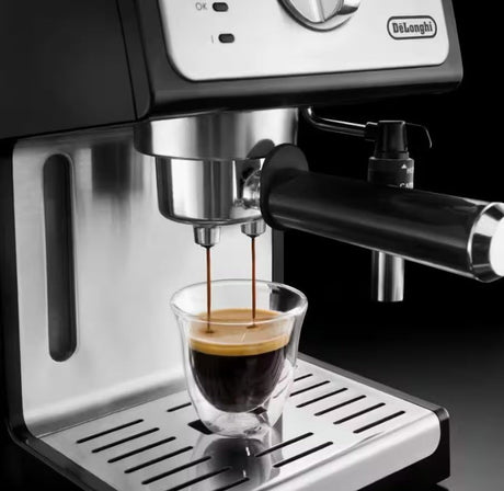 Taghareed De'Longhi ECP 35.31 espresso machine brewing coffee into a glass cup, black and stainless steel finish.