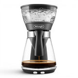 Taghareed De'Longhi ICM17210 black glass filter coffee maker with 1.25L carafe, brewing coffee.