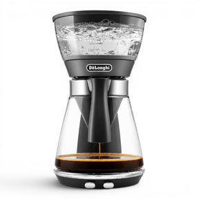 Taghareed De'Longhi ICM17210 black glass filter coffee maker with 1.25L carafe, brewing coffee.