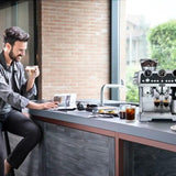 Taghareed De'Longhi La Specialista Maestro espresso machine in silver, with built-in grinder and dual milk system.