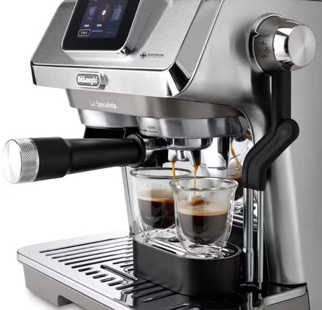 Taghareed De'Longhi La Specialista Touch EC9455.M stainless steel espresso machine brewing two shots of espresso into glass cups.