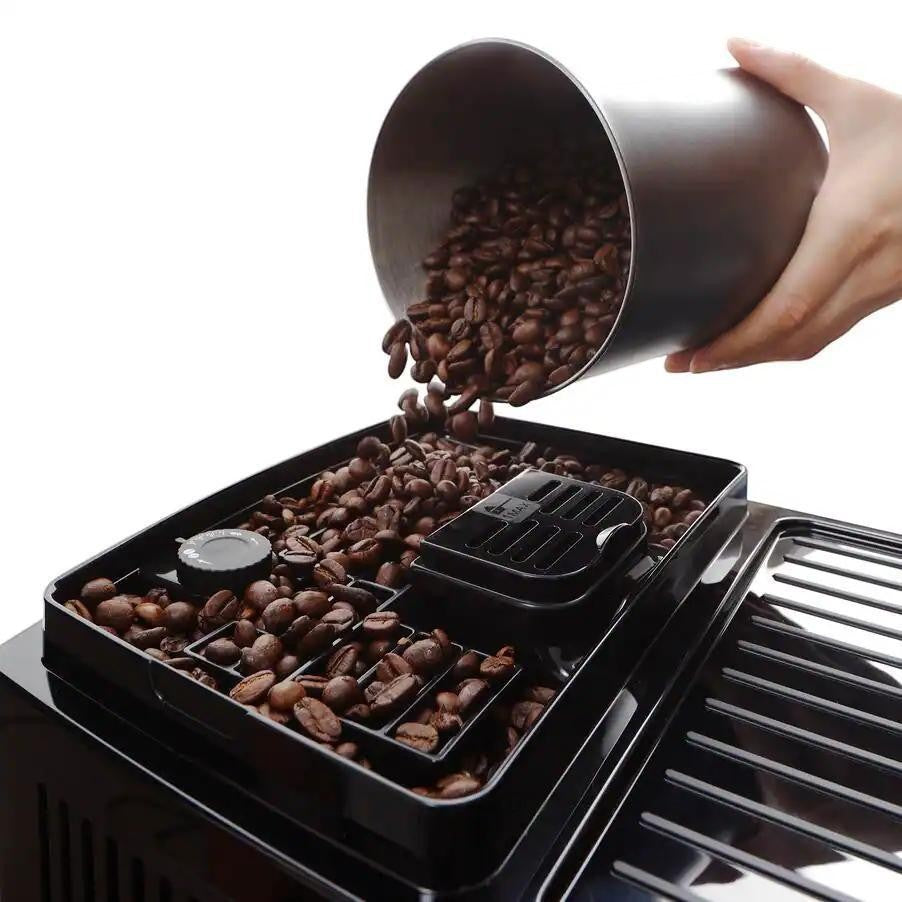 Taghareed De'Longhi Magnifica Start coffee machine bean hopper being filled with fresh coffee beans.