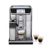 Taghareed De’Longhi PrimaDonna Elite Experience fully automatic coffee machine in stainless steel with a touchscreen and milk carafe, brewing a latte.