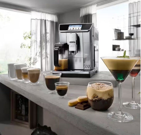 Taghareed De’Longhi PrimaDonna Elite stainless steel automatic coffee machine with touch screen, making various coffee drinks.