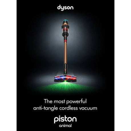 Taghareed Dyson V16 Piston Animal Submarine cordless vacuum in copper and black with illuminated brush head cleaning green particles.