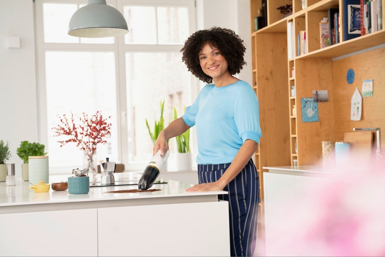 Taghareed Kärcher CVH 2 cordless hand vacuum cleaner with HEPA filter cleaning kitchen counter.