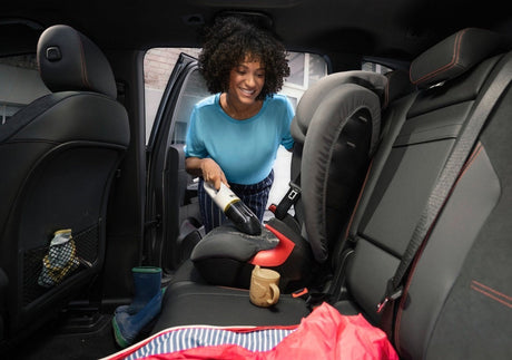 Taghareed Kärcher CVH 2 cordless hand vacuum cleaner with HEPA filter, used by a woman to clean a car seat.