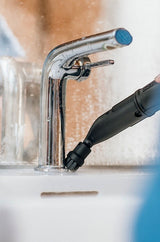 Taghareed Karcher SC 4 EasyFix steam cleaner with brush attachment cleaning a chrome faucet in a white sink.