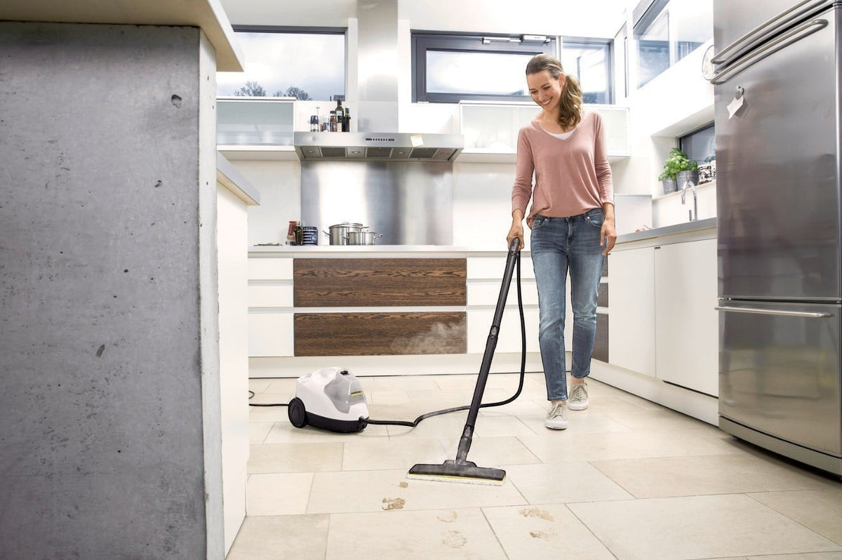Taghareed Karcher SC 4 EasyFix steam cleaner with floor nozzle cleaning a tiled kitchen floor. White and yellow unit.