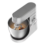 Taghareed Kenwood Chef XL stand mixer in silver, 1200W with 6.7L stainless steel bowl, mixing batter.