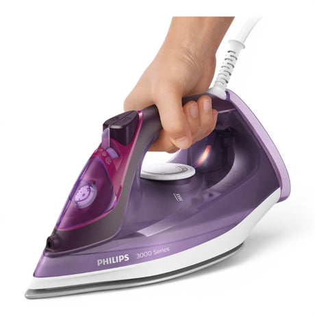 Taghareed Philips 3000 Series steam iron with purple translucent body and white soleplate, held by a hand.