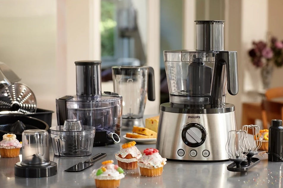 Taghareed: Philips 7000 Series food processor with stainless steel base, multiple attachments, and cupcakes.