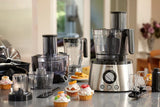 Taghareed: Philips 7000 Series food processor with stainless steel base, multiple attachments, and cupcakes.