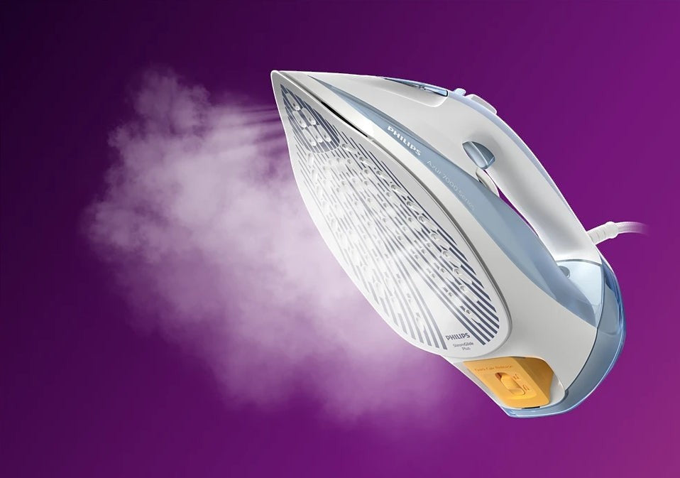 Taghareed Philips 7000 Series steam iron, white and light blue, with SteamGlide Plus soleplate and steam output.