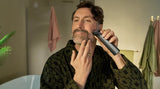 Taghareed man grooming beard with Philips All-in-One Trimmer 7000 Series MG7922/15, featuring 13 attachments and BeardSense technology.