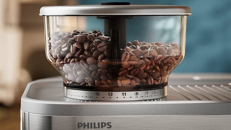 Taghareed Philips Barista Brew semi-automatic espresso machine with built-in grinder and 58mm stainless steel filter, filled with coffee beans.