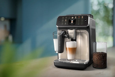 Taghareed Philips 5500 Series espresso machine with LatteGo system, brewing a latte macchiato. Features TFT screen, ceramic grinder, 15 bar pressure.