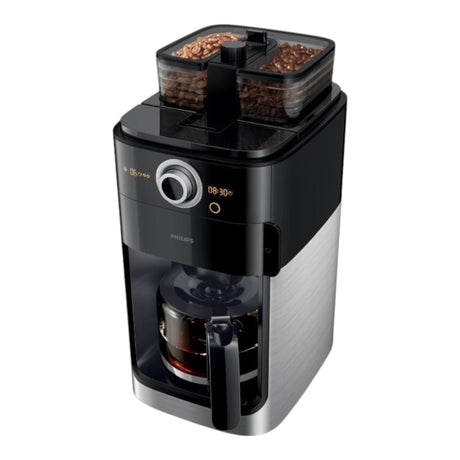 Taghareed Philips Grind & Brew coffee maker with dual bean hoppers, built-in grinder, and glass carafe. Black and silver.